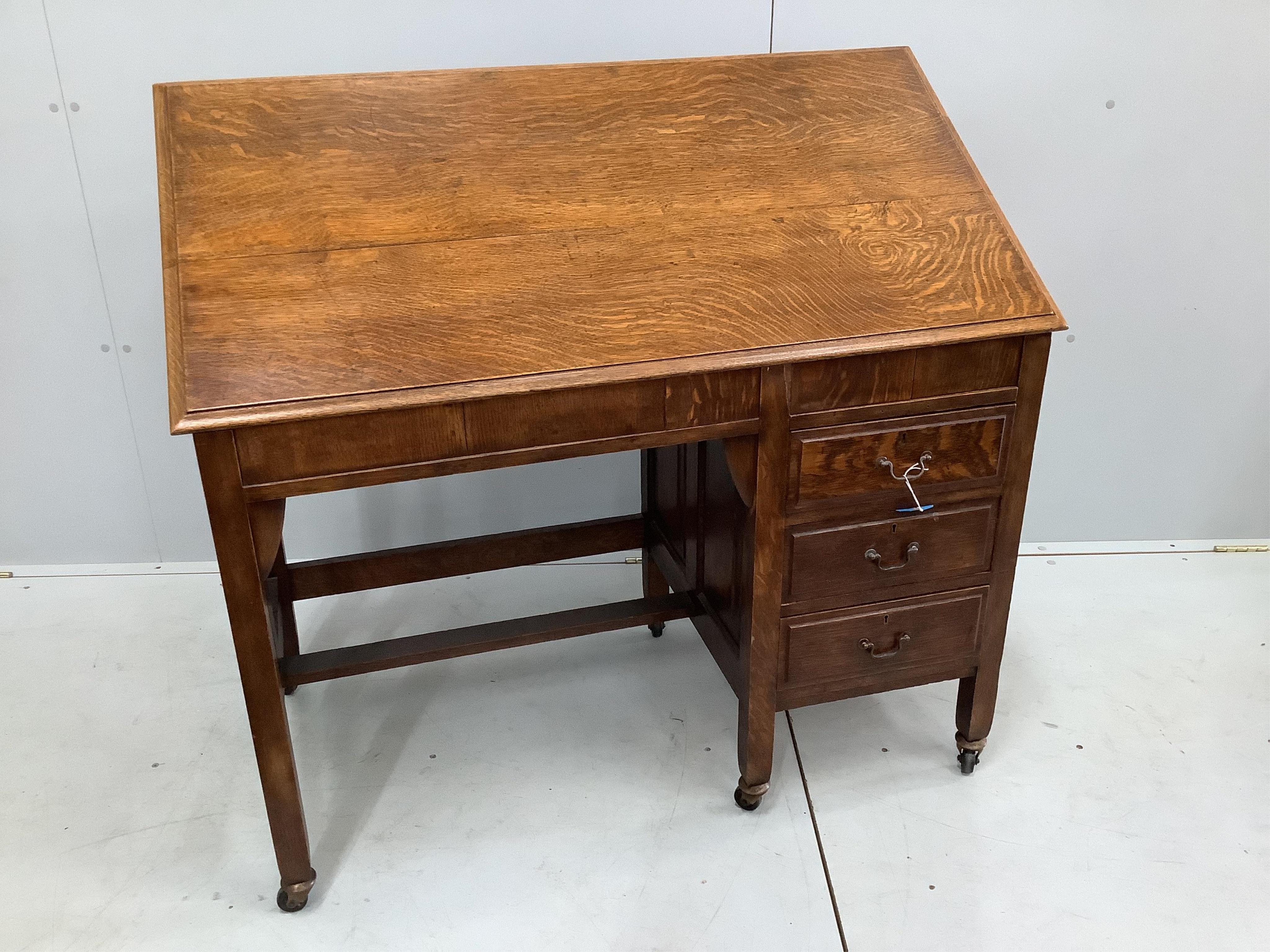 An Arts & Crafts metamorphic oak patent kneehole architect's desk, fitted three small side drawers, width 108cm, depth 56cm, height 72cm. Condition - fair